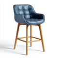 Sgabello alto con seduta trapuntata blu in ecopelle e gambe in legno di frassino
